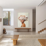 Minimalist interior with terrazzo flooring, wooden benches, staircase, and a surreal painting of a woman with clouds on her head.
