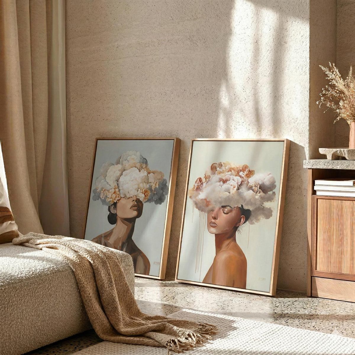Two framed acrylic paintings of women with clouds obscuring their heads leaning against a textured wall.